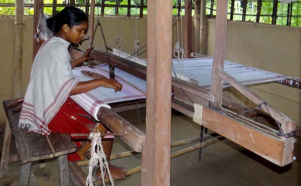 A young woman handles a hand loom of the small weaving mill established in 2015